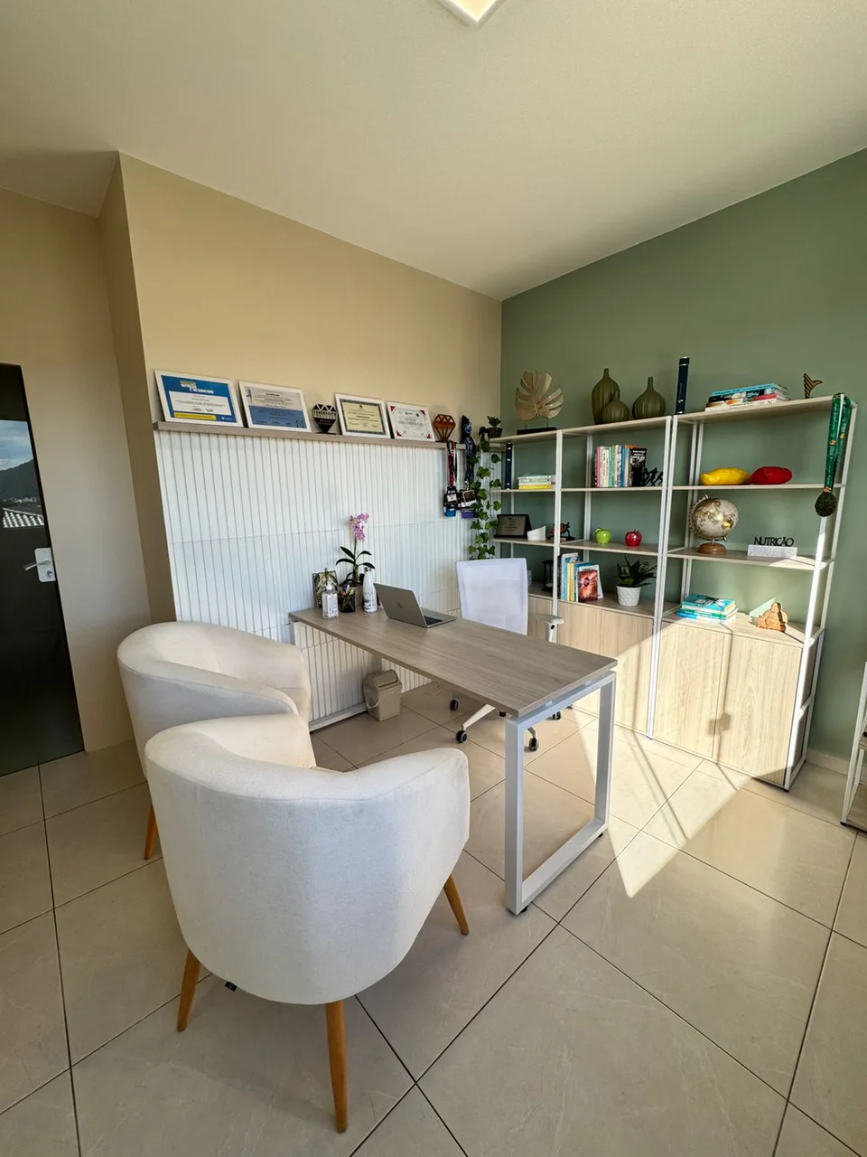 Área de atendimento do consultório de Mariana Sander, com mesa e poltronas.
